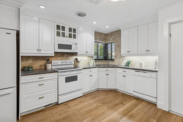 a kitchen with stainless steel appliances granite countertop a sink and cabinets