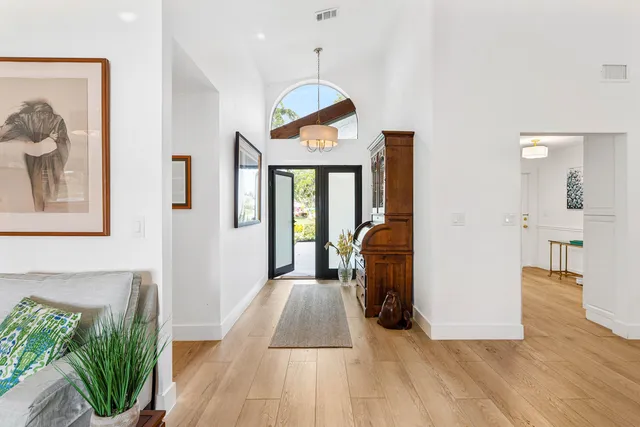 a kitchen with granite countertop white cabinets and white appliances with wooden floor