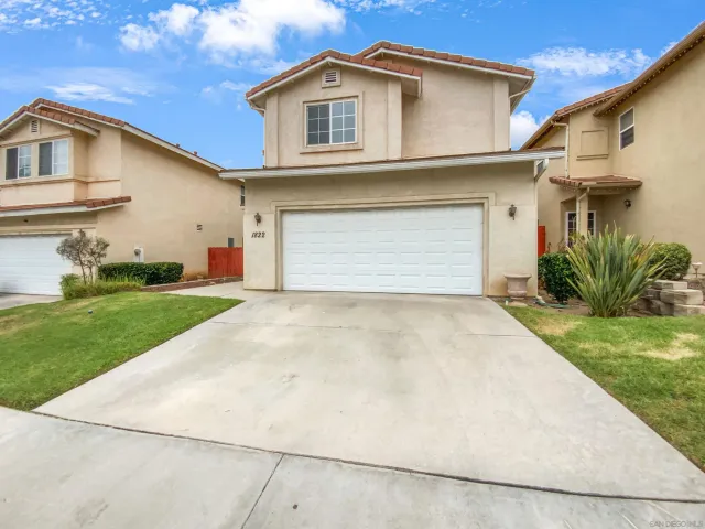 a view of a white house with a yard and garage