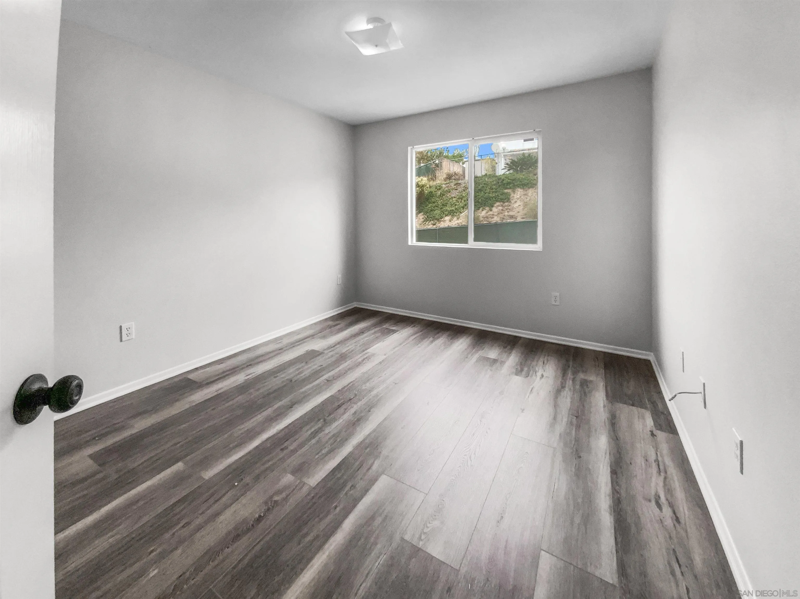 1822 McDougal Terrace El Cajon, CA 92021 - Photo 16 of 17 an empty room with wooden floor and windows