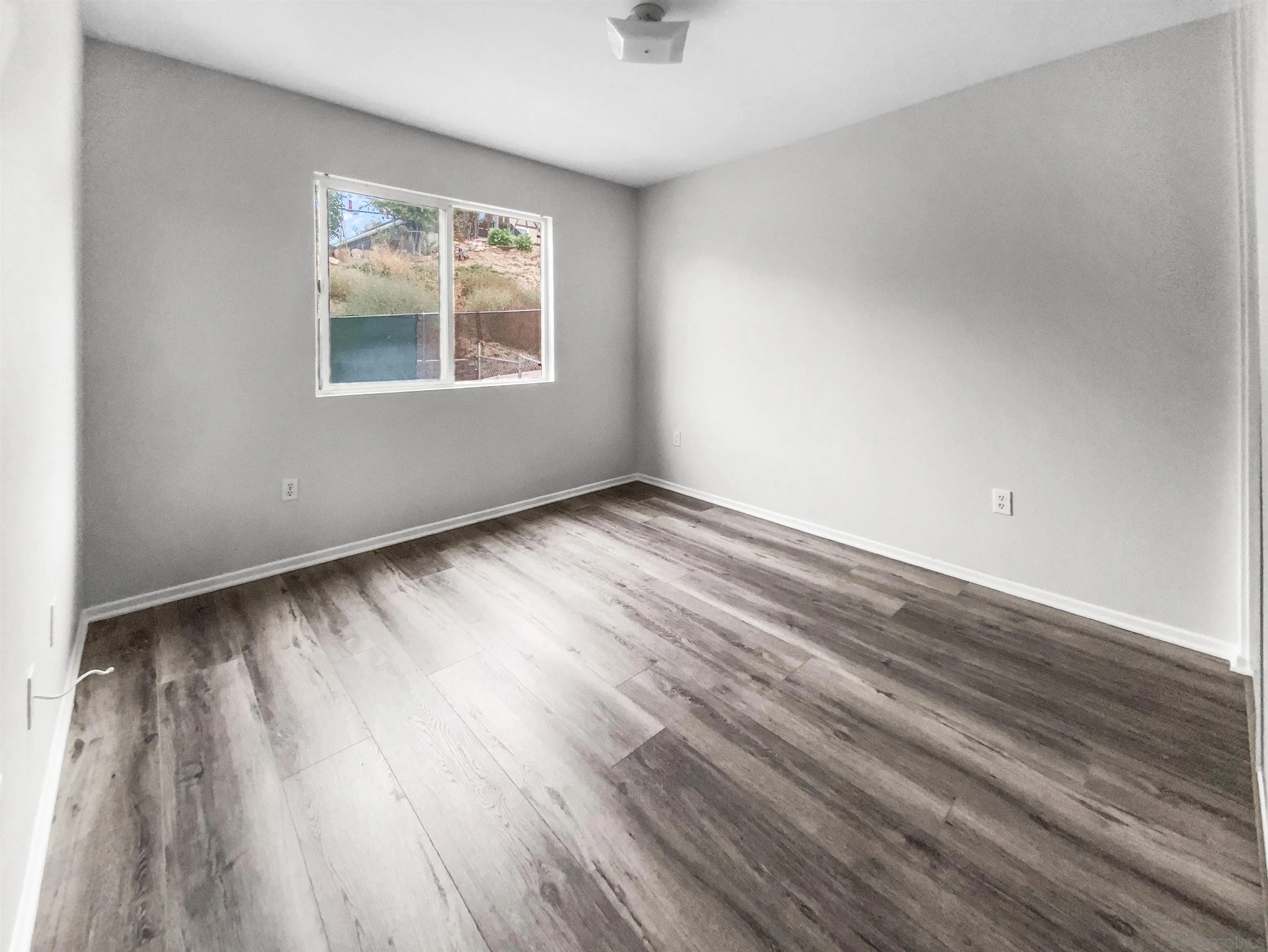 1822 McDougal Terrace El Cajon, CA 92021 - Photo 5 of 17 an empty room with wooden floor and windows