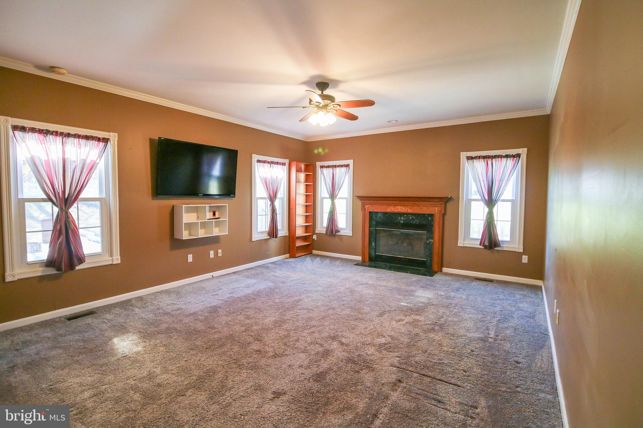 56 Cross Point Drive Owings, MD 20736 - Photo 14 of 54 en empty room with windows fireplace and flat screen tv