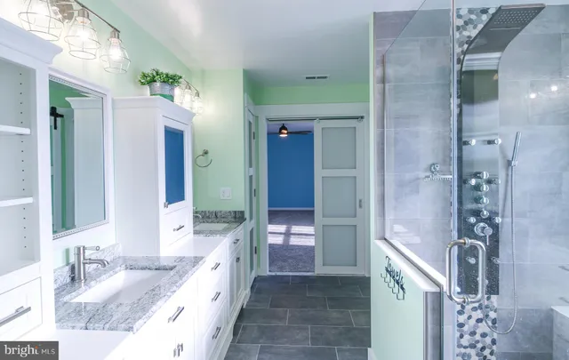 a bathroom with a granite countertop sink toilet and shower