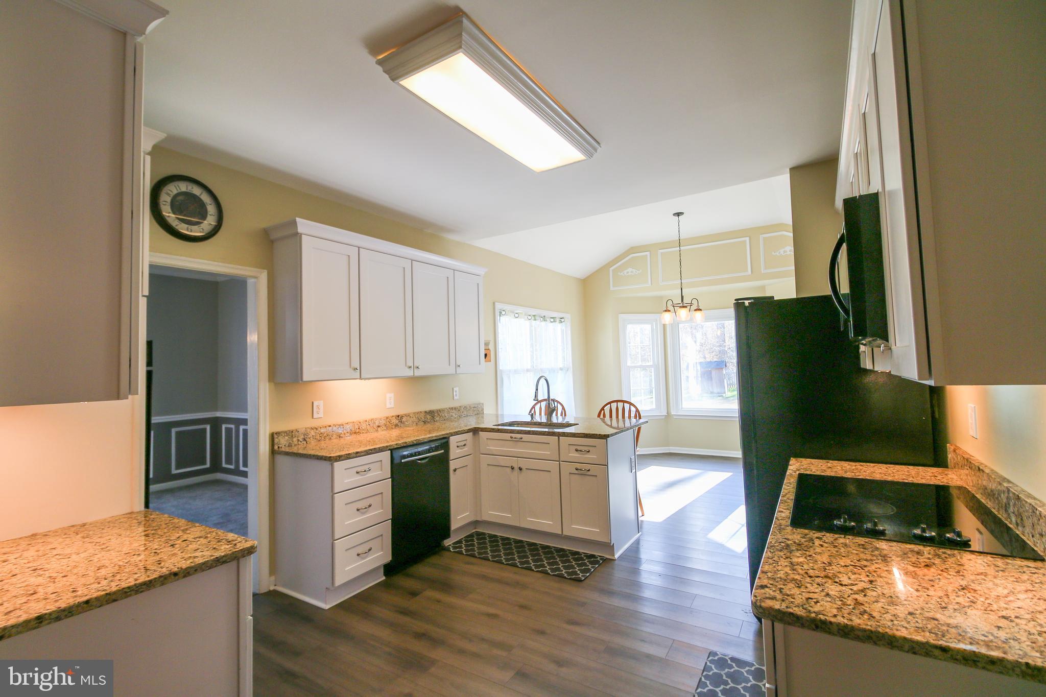 56 Cross Point Drive Owings, MD 20736 - Photo 6 of 54 a kitchen with granite countertop a stove a sink and a refrigerator