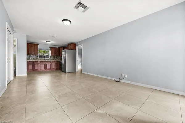 a view of kitchen with refrigerator and cabinets
