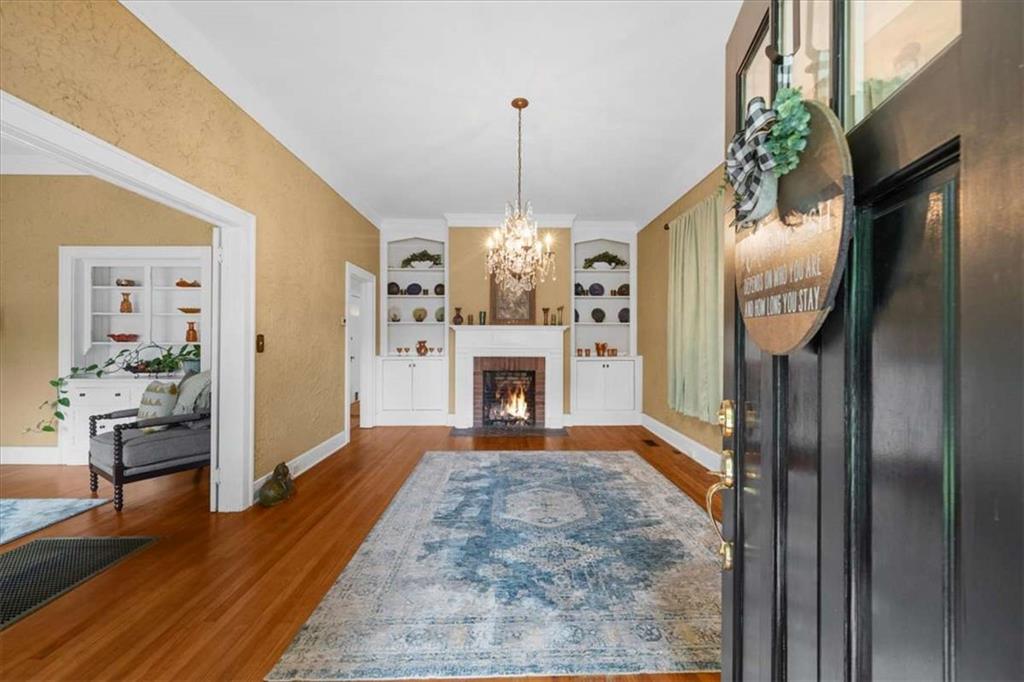 106 Westmore Road Southwest Rome, GA 30165 - Photo 5 of 56 a view of a livingroom with wooden floor a fireplace a chandelier and windows