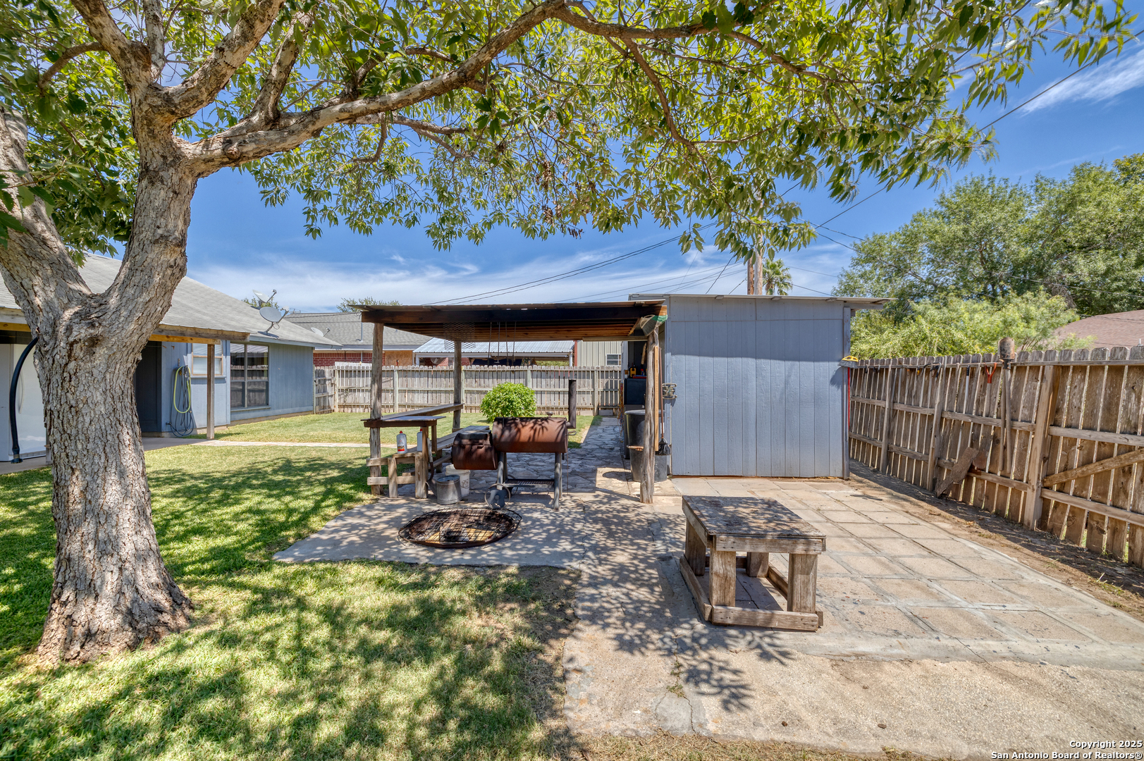 121 Rio Grande Street Uvalde, TX 78801 - Photo 16 of 29 a view of backyard with table and chairs and a large tree