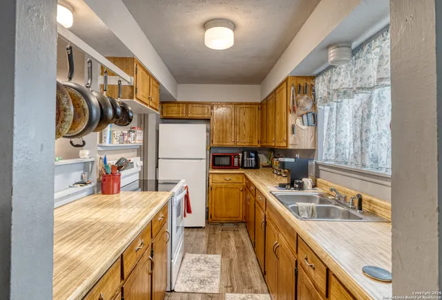 a kitchen that has a sink a stove and a refrigerator