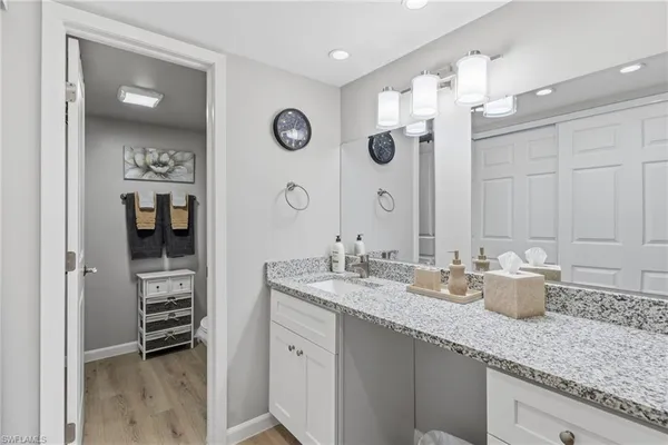 a bathroom with a granite countertop sink and a mirror