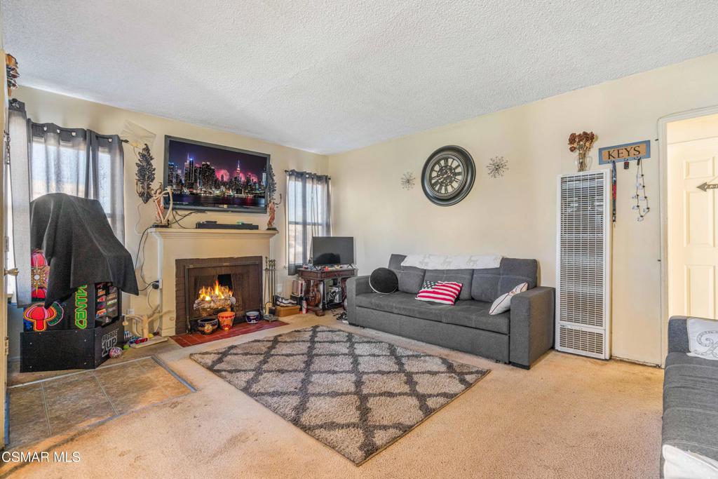 344 North 1st Street Montebello, CA 90640 - Photo 5 of 16 a living room with furniture a flat screen tv and a fireplace