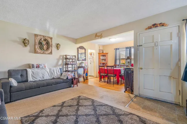 a living room with furniture and a kitchen area