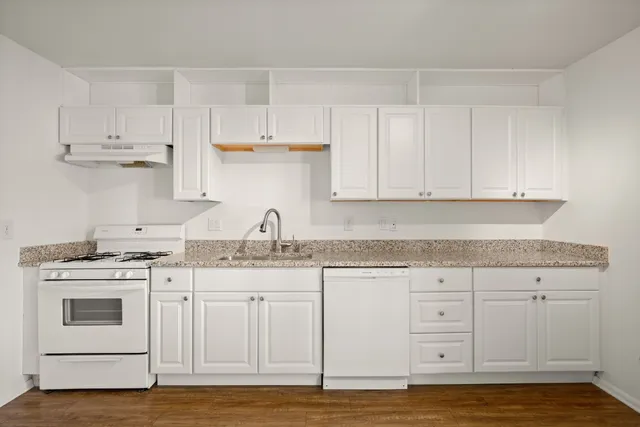 a kitchen with stainless steel appliances granite countertop a sink and cabinets with wooden floor