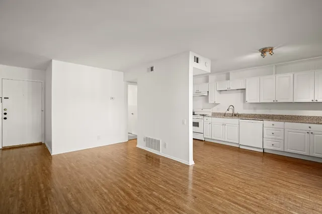 a kitchen with wooden floors and white appliances