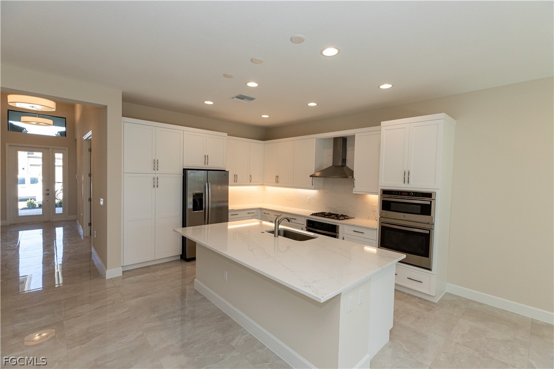 12801 Springbrook Court Estero, FL 33928 - Photo 16 of 49 a kitchen with a refrigerator and a stove top oven