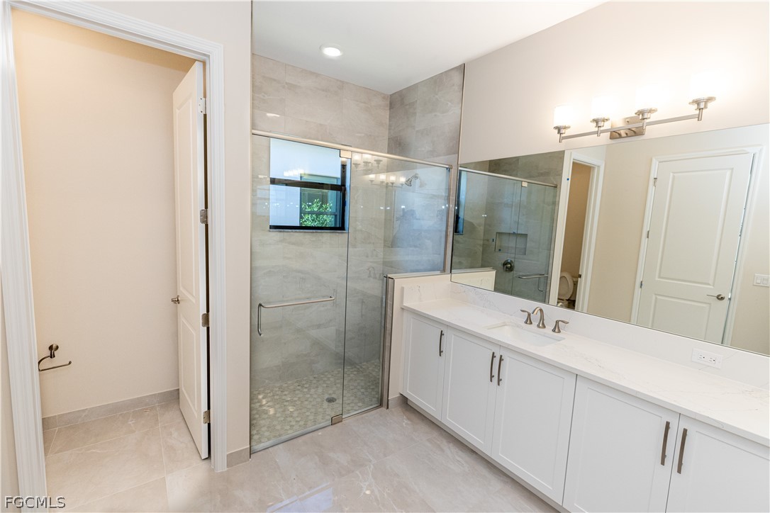 12801 Springbrook Court Estero, FL 33928 - Photo 24 of 49 a bathroom with a double vanity sink mirror and shower