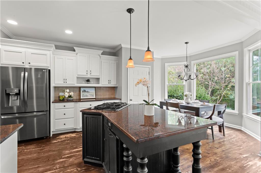 108 Laurel Street Canton, GA 30114 - Photo 6 of 33 a kitchen with stainless steel appliances granite countertop a table chairs wooden floors and a large window