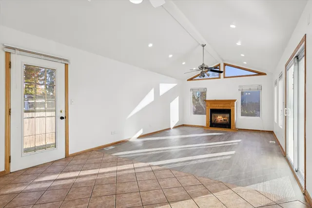 a view of an empty room with a fireplace and a window