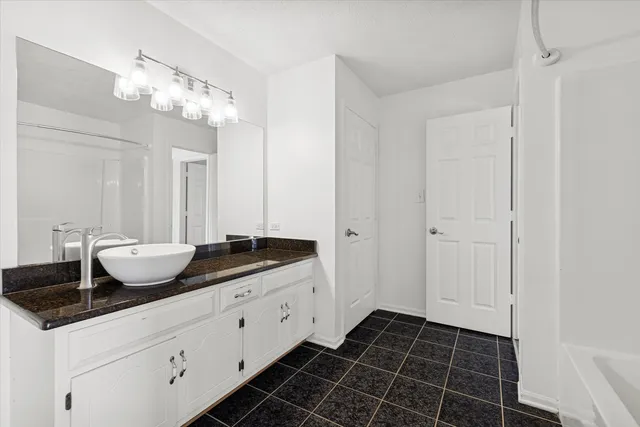 a bathroom with a granite countertop sink a mirror and vanity