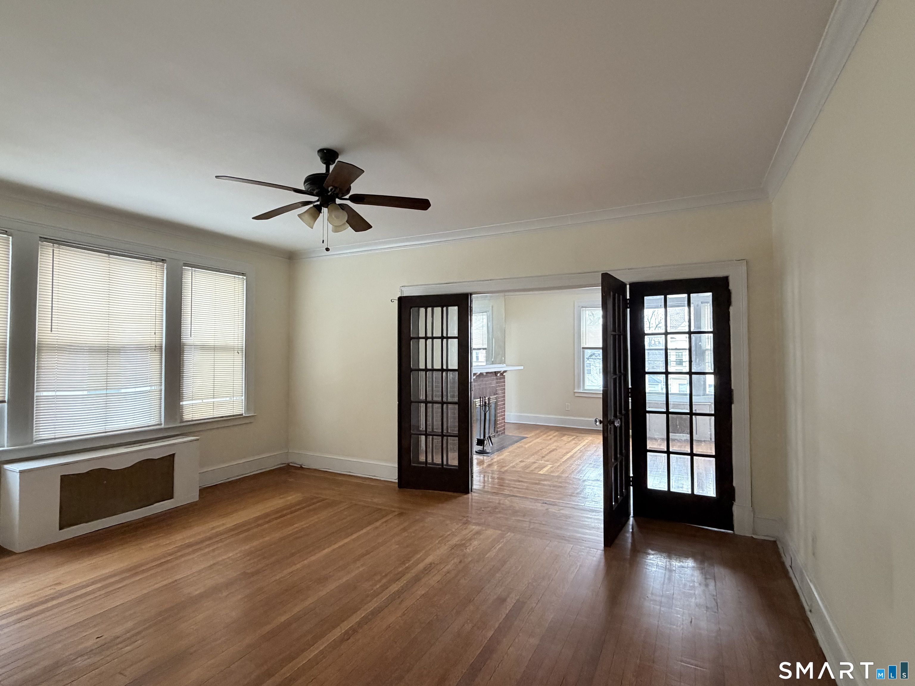 41-43 Hebron Street Hartford, CT 06112 - Photo 5 of 13 an empty room with wooden floor and windows