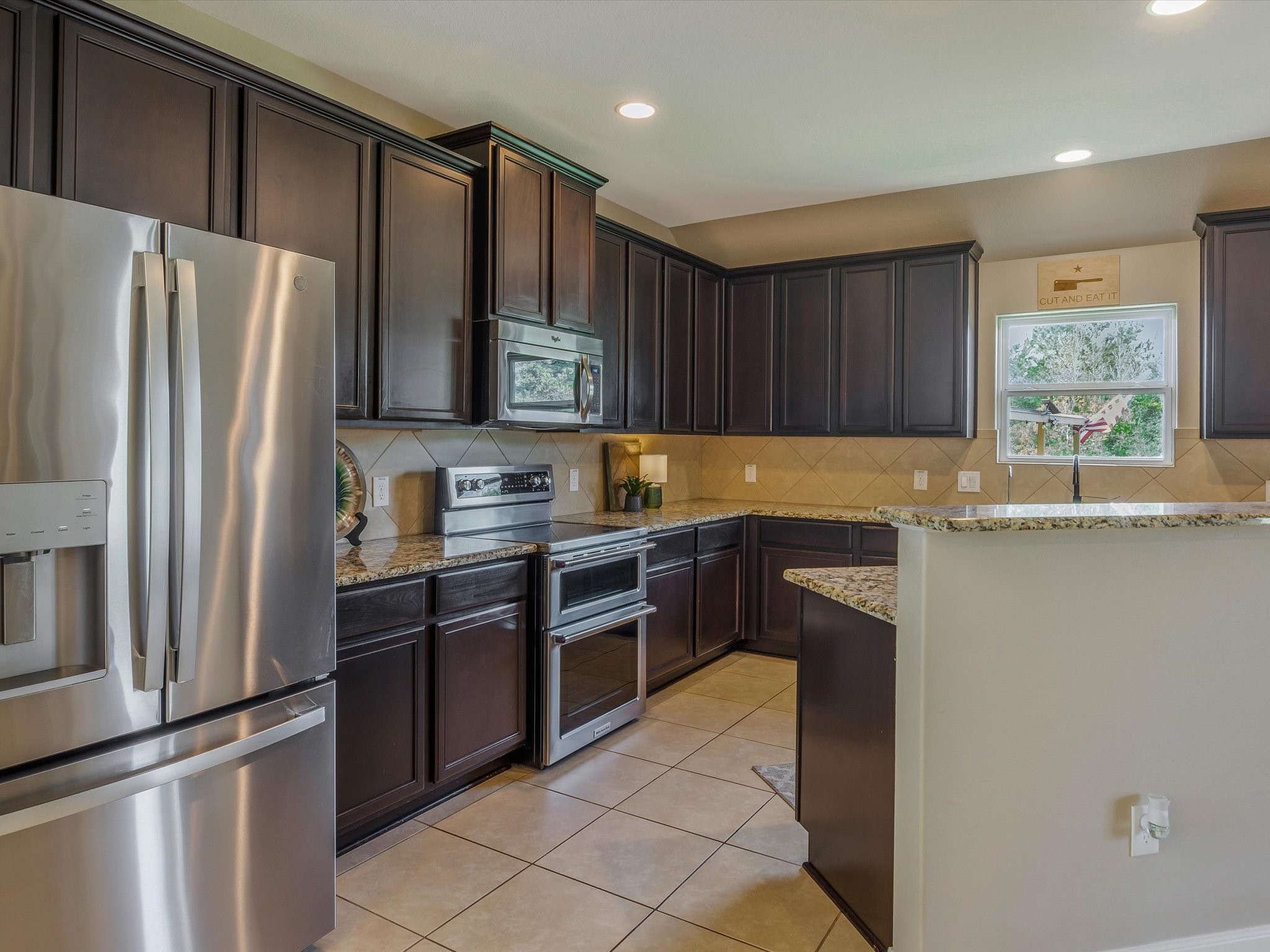 18746 Encinal Trail Magnolia, TX 77355 - Photo 13 of 35 a kitchen with granite countertop stainless steel appliances and wooden cabinets