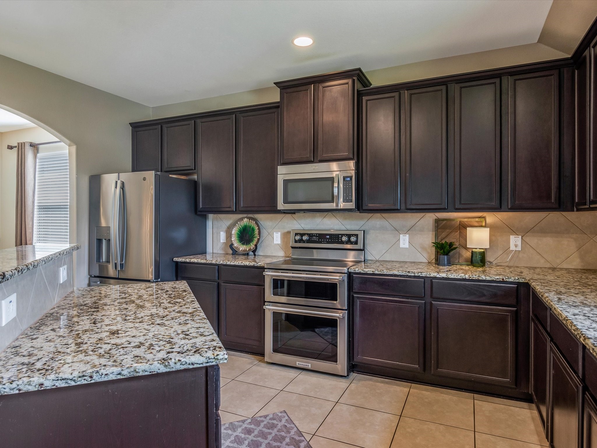 18746 Encinal Trail Magnolia, TX 77355 - Photo 14 of 35 a kitchen with kitchen island granite countertop wooden cabinets stainless steel appliances and a counter space