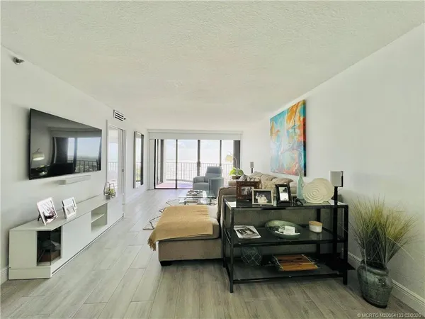 a living room with furniture and a floor to ceiling window