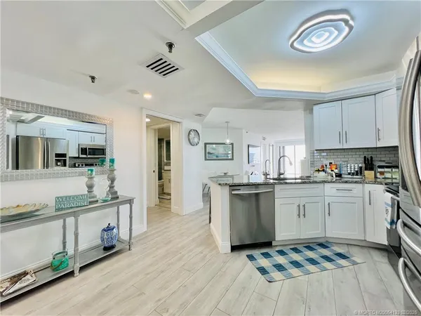 a kitchen with granite countertop stainless steel appliances a refrigerator and a stove top oven