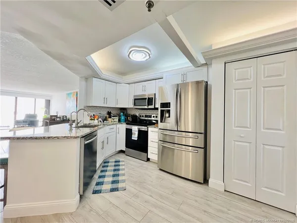a kitchen with stainless steel appliances granite countertop a refrigerator and a stove top oven