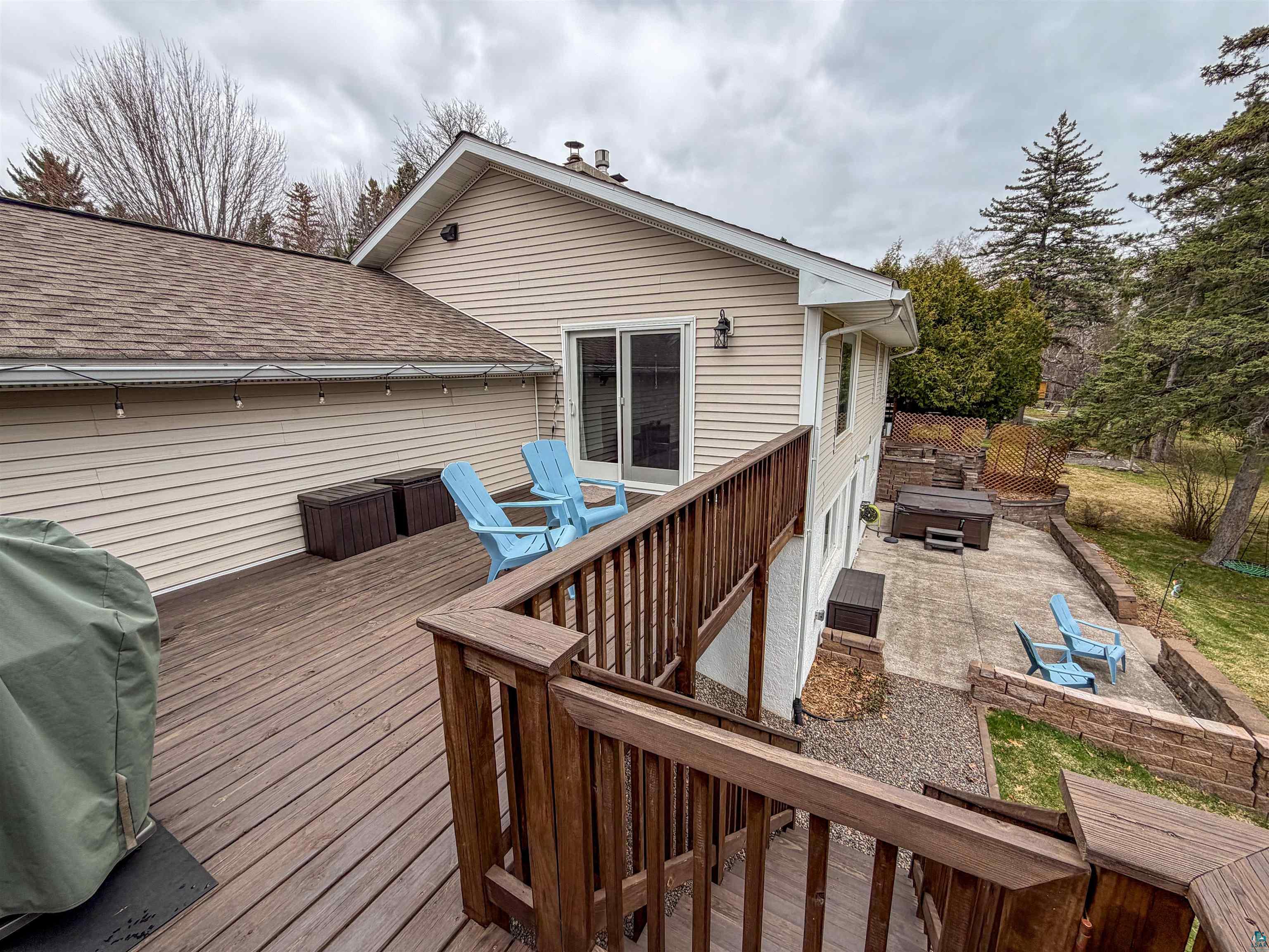 3704 Greysolon Road Duluth, MN 55804 - Photo 40 of 51 Multi-level outdoor living space featuring a spacious wood-finish deck with a wooden railing system, a lower patio area, and a hot tub