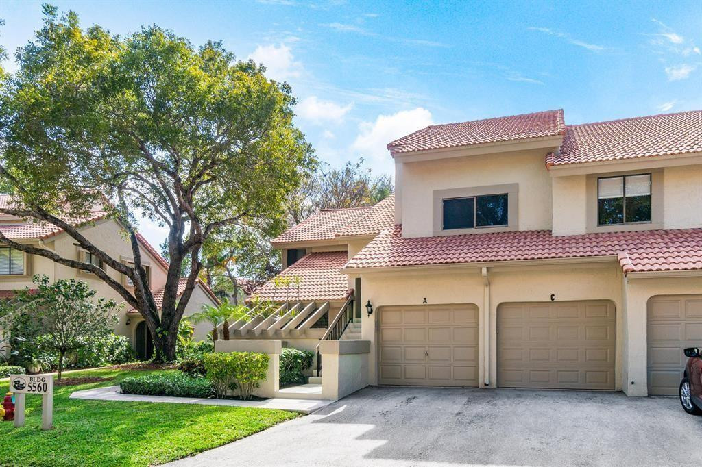 5560 Coach House Circle, Unit C Boca Raton, FL 33486 - Photo 1 of 19 a front view of a house with a yard