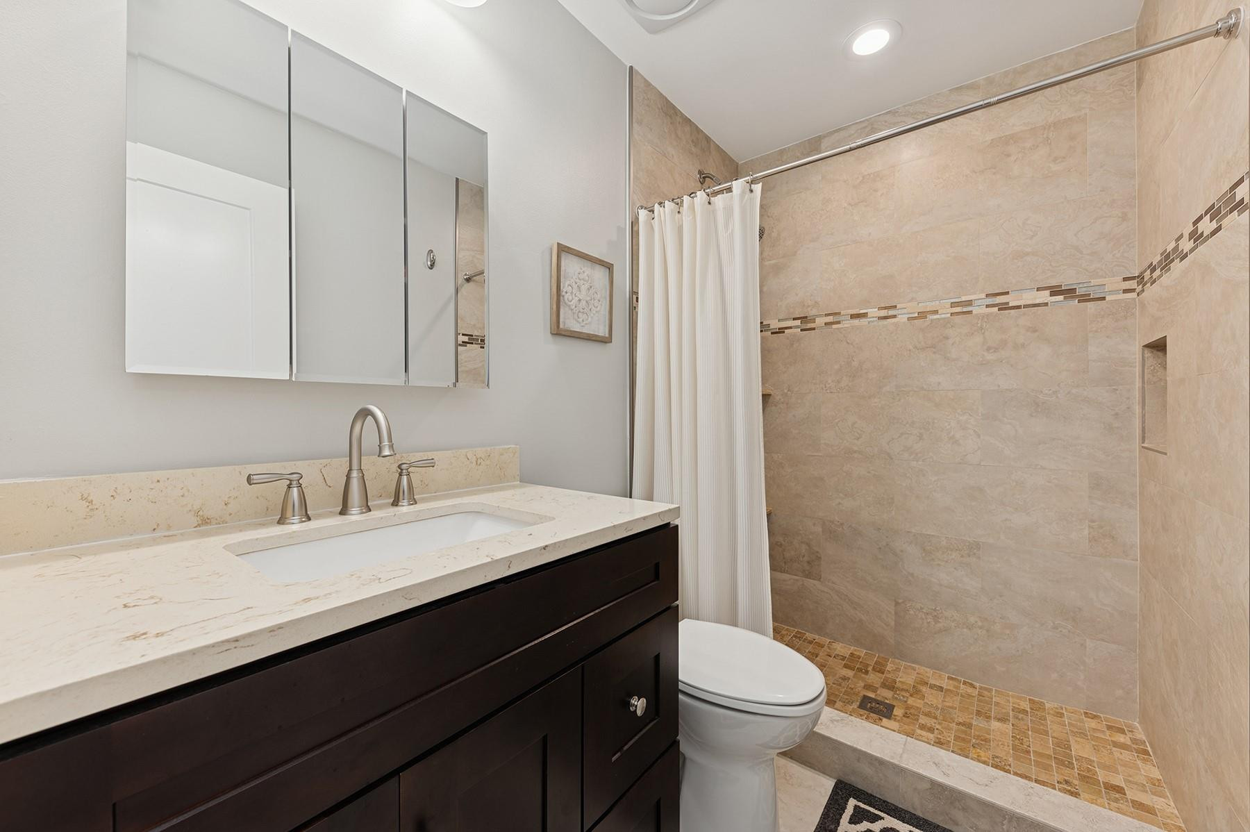 5560 Coach House Circle, Unit C Boca Raton, FL 33486 - Photo 17 of 19 a bathroom with a sink a toilet a mirror and shower