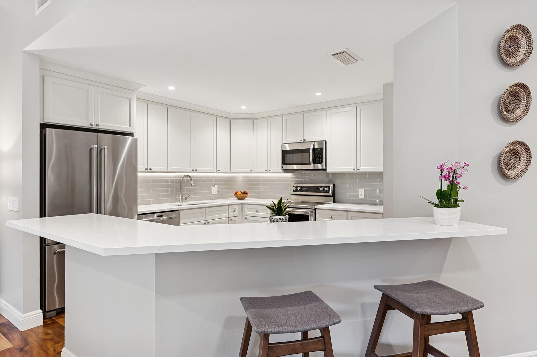 5560 Coach House Circle, Unit C Boca Raton, FL 33486 - Photo 8 of 19 a kitchen with stainless steel appliances a microwave sink and refrigerator