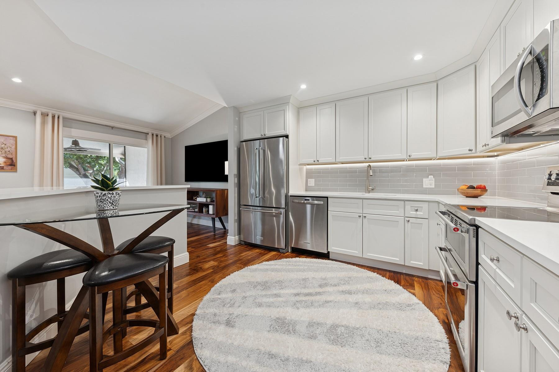 5560 Coach House Circle, Unit C Boca Raton, FL 33486 - Photo 9 of 19 a kitchen with a table chairs refrigerator and cabinets