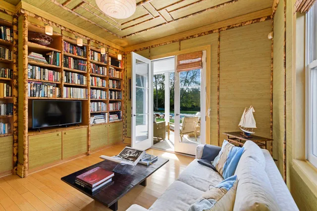 a living room with furniture a flat screen tv and a floor to ceiling window