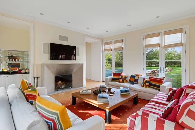 a living room with furniture a flat screen tv and a fireplace