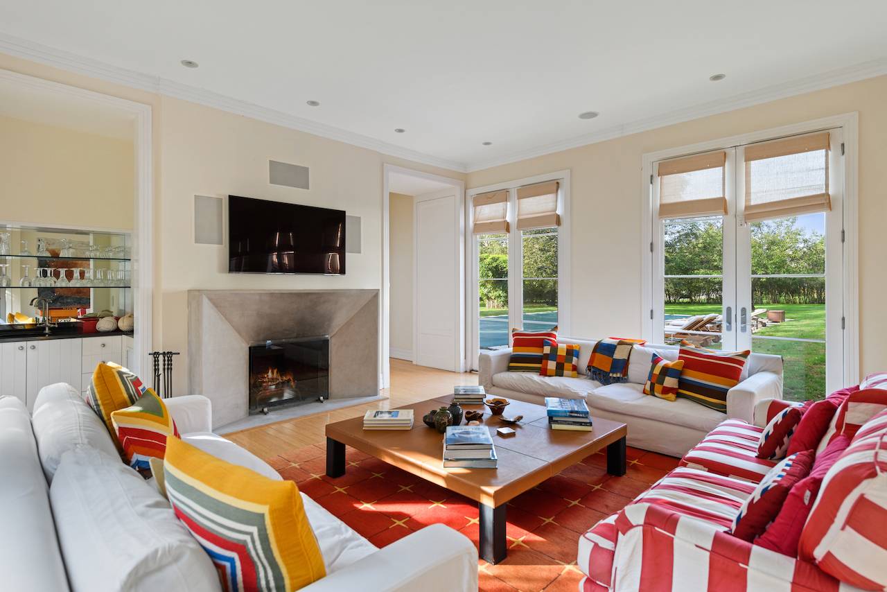 244 Flying Point Road Water Mill, NY 11976 - Photo 6 of 22 a living room with furniture a flat screen tv and a fireplace
