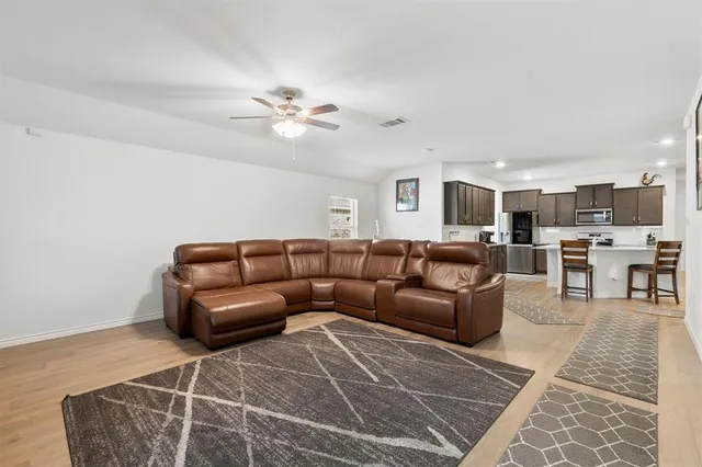 a living room with furniture and a ceiling fan