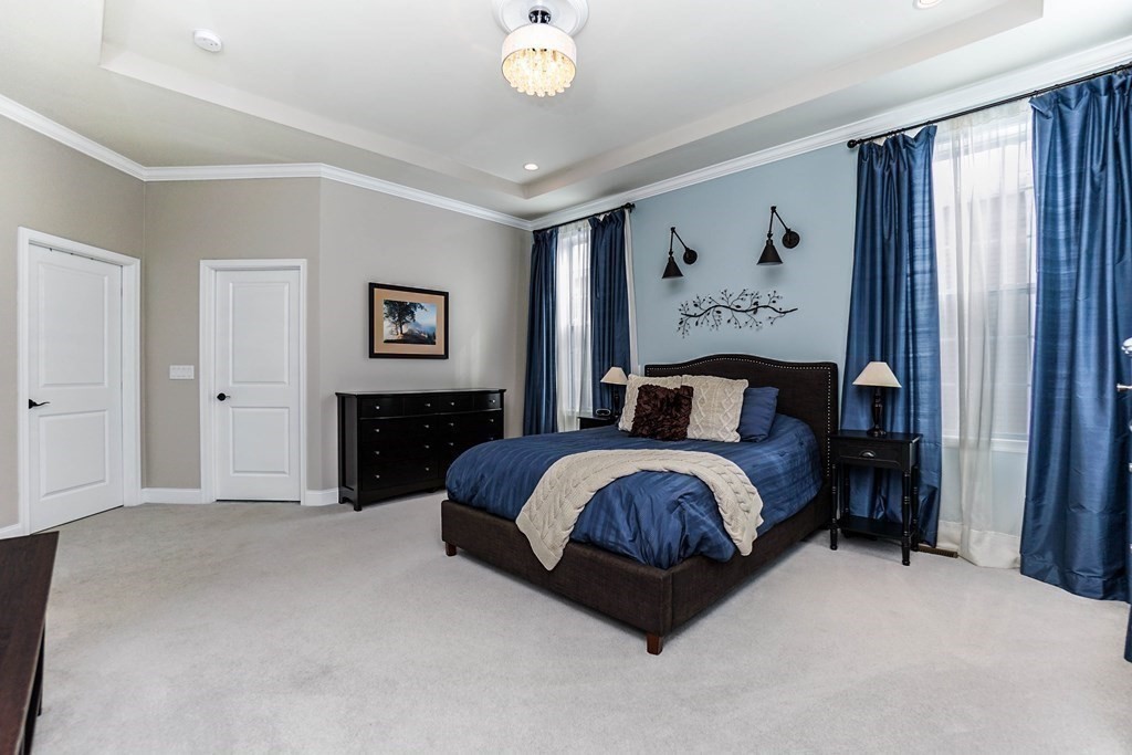 27 Pine Tree Drive, Unit 27 Methuen, MA 01844 - Photo 13 of 39 a spacious bedroom with a bed and a chandelier