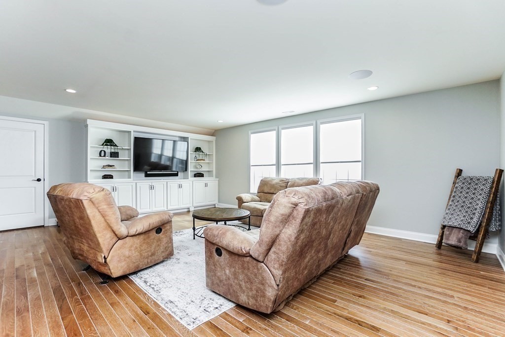 27 Pine Tree Drive, Unit 27 Methuen, MA 01844 - Photo 23 of 39 a living room with furniture a flat screen tv and a wooden floor