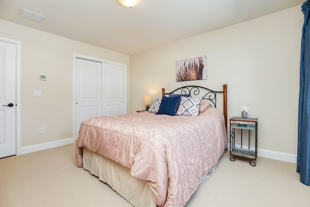 27 Pine Tree Drive, Unit 27 Methuen, MA 01844 - Photo 32 of 39 a bedroom with a bed and a chandelier