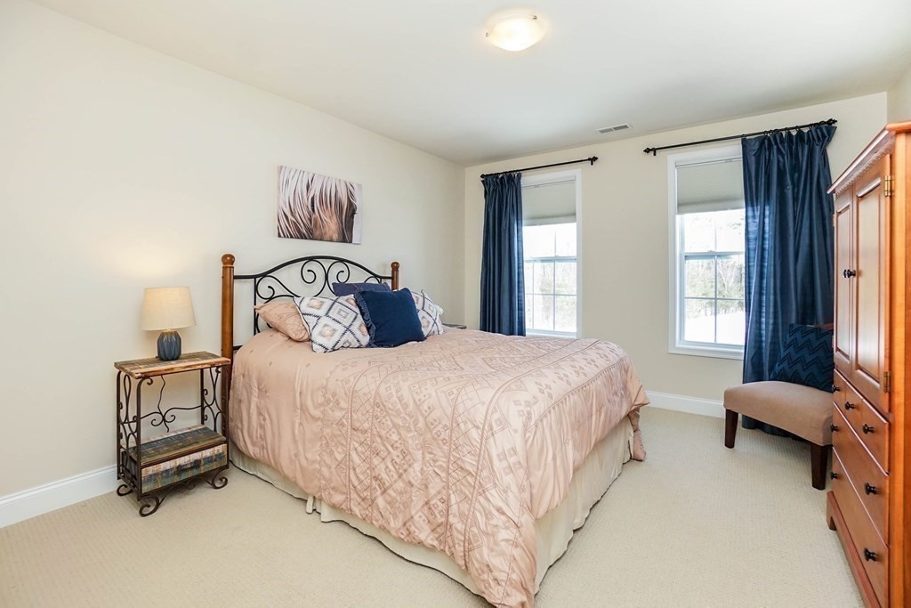 27 Pine Tree Drive, Unit 27 Methuen, MA 01844 - Photo 33 of 39 a bedroom with a bed and a chandelier