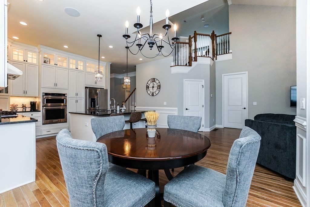 27 Pine Tree Drive, Unit 27 Methuen, MA 01844 - Photo 5 of 39 a dining room with wooden floor a chandelier a wooden table and chairs
