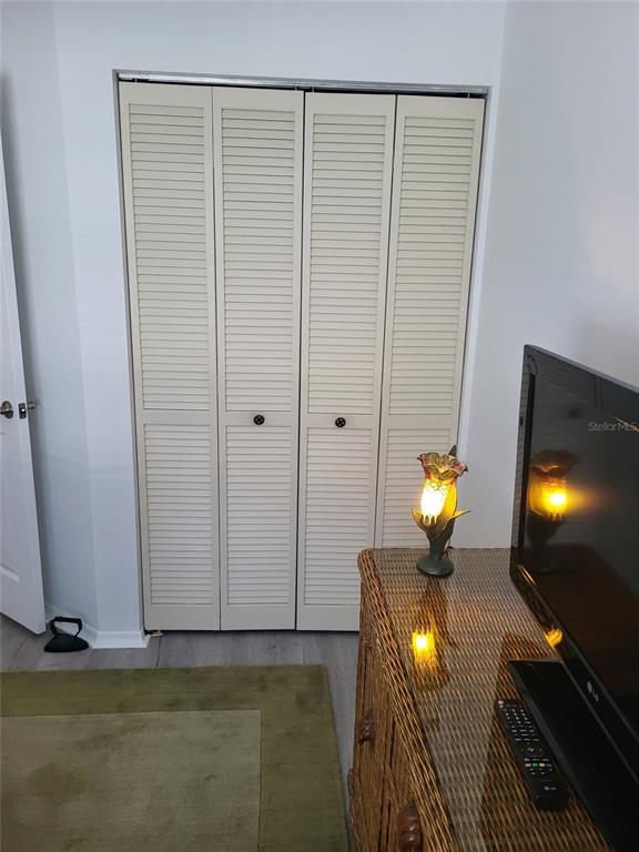 482 Pendleton Place Venice, FL 34292 - Photo 24 of 54 a view of an empty room with wooden floor and a lamp