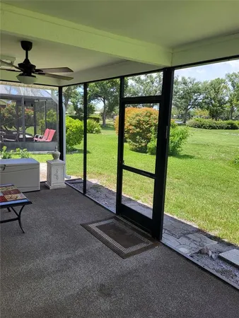 a view of a backyard with a table and chairs under an umbrella with a garden
