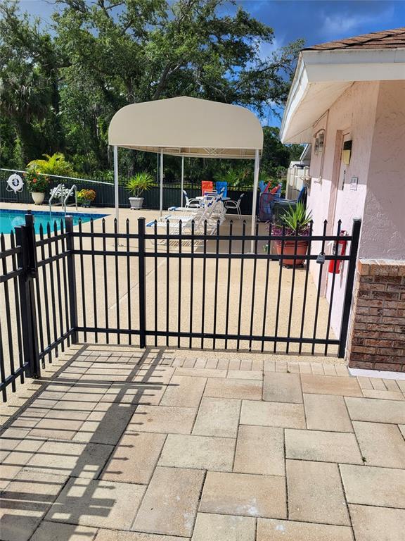482 Pendleton Place Venice, FL 34292 - Photo 50 of 54 a view of a backyard with a table and chairs under an umbrella with a garden