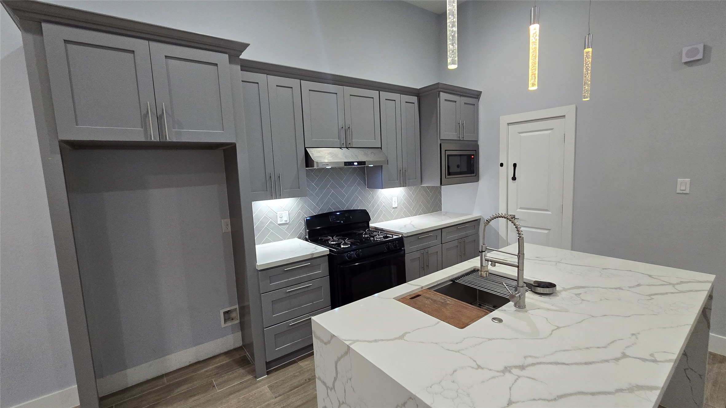 10017 Morocco Road Houston, TX 77041 - Photo 7 of 24 a kitchen with stainless steel appliances a stove a sink and a refrigerator with wooden floor