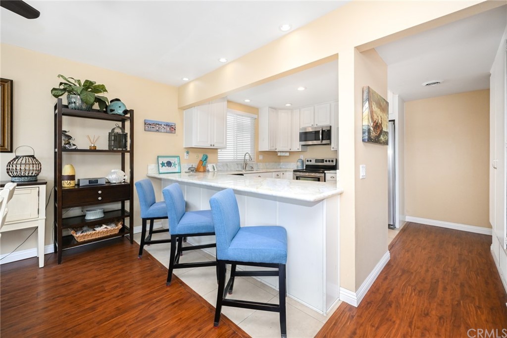 5100 Seashore Drive Newport Beach, CA 92663 - Photo 14 of 67 a kitchen with stainless steel appliances granite countertop a stove a sink and a refrigerator with wooden floor