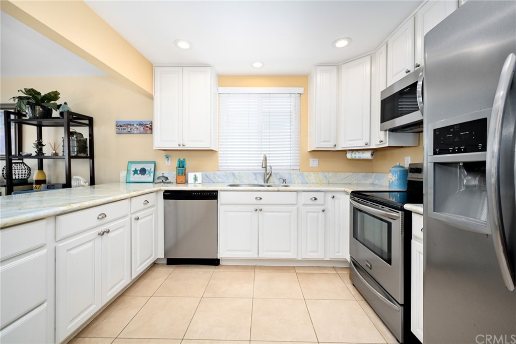 5100 Seashore Drive Newport Beach, CA 92663 - Photo 17 of 67 a kitchen with stainless steel appliances granite countertop a refrigerator sink and cabinets