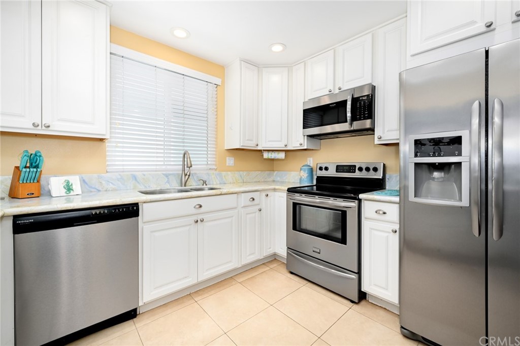 5100 Seashore Drive Newport Beach, CA 92663 - Photo 18 of 67 a kitchen with white cabinets and stainless steel appliances