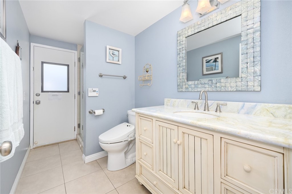5100 Seashore Drive Newport Beach, CA 92663 - Photo 41 of 67 a bathroom with a granite countertop sink a toilet and a mirror